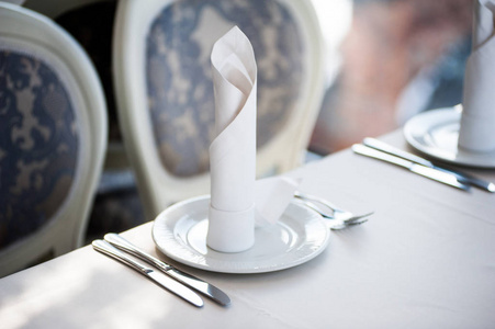 宴会装饰的桌子，有餐具。宴会厅的婚礼装饰..提供节日餐桌餐盘餐巾纸刀叉.台面装饰。浪漫晚宴或其他活动。