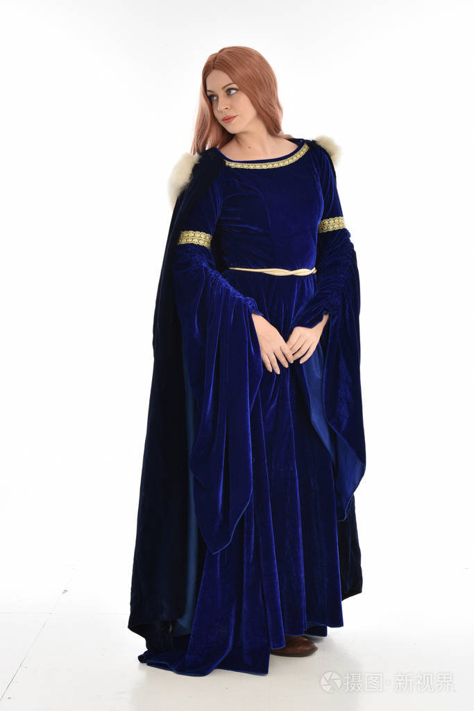 穿着蓝色天鹅绒中世纪长袍和毛皮斗篷的长发妇女的全长肖像.