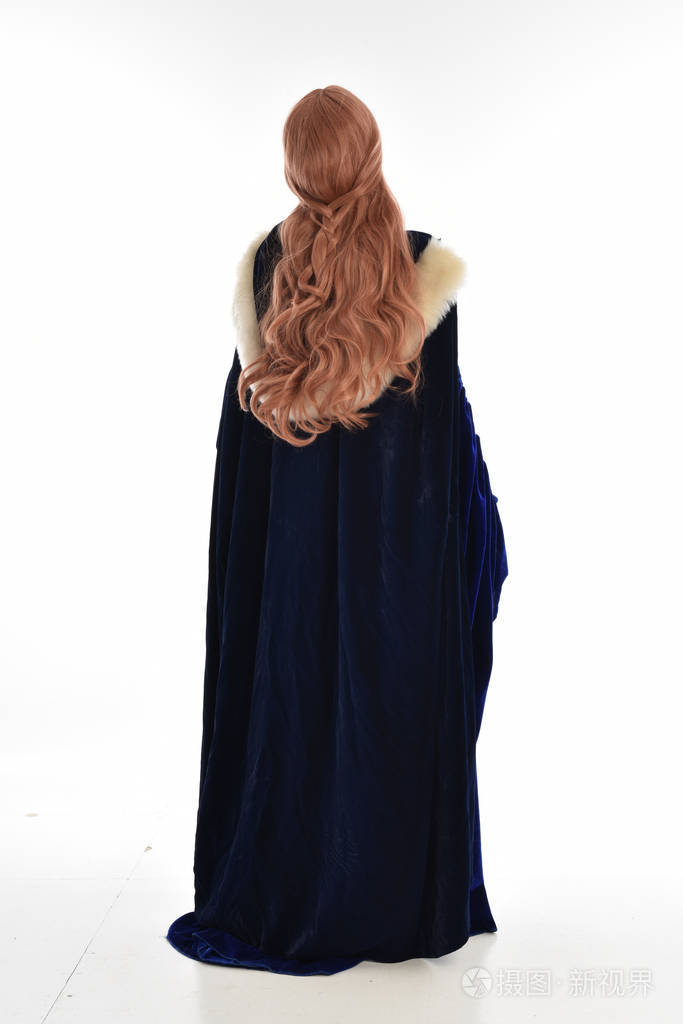 穿着蓝色天鹅绒中世纪长袍和毛皮斗篷的长发妇女的全长肖像.