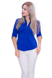 工作室商业肖像一个年轻的金发女人穿着深蓝色衬衫和白色裤子。 女孩在孤立的白色背景上摆姿势。 微笑着看着摄像机