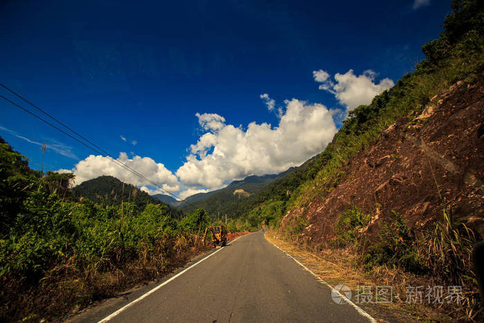 阳光普照的公路，山峦间的景色，在车窗外的蓝天上