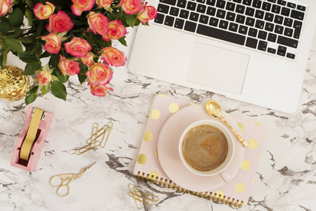 女性工作场所的概念。 自由职业工作空间的平面布局风格与笔记本电脑咖啡花，黄金菠萝笔记本和回形针在白色大理石背景。 顶景明亮的粉红