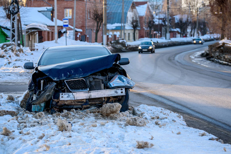 城市碰撞后街道上损坏汽车的车祸。 冬季道路积雪。