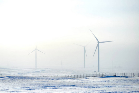 风力发电厂在冬天。风力发电是利用气流通过风力涡轮机来机械地为发电机供电。 风电场是一组风力涡轮机，在同一地点用于生产电力。