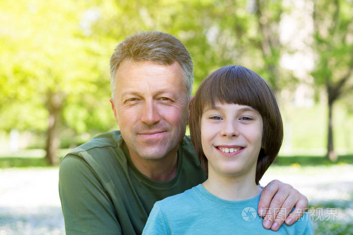 父子俩在阳光明媚的春天公园里一起摆造型f