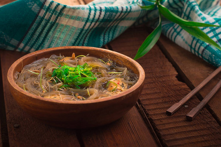 日式料理, 汤配有 chashu 猪肉韭菜豆芽面条和海藻在桌下的阳光下。木制乡村背景。顶部视图