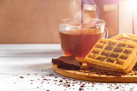 自制的华夫饼, 旧木桌上有果酱。杯茶, 茶壶, 巧克力的晶片