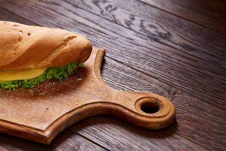 新鲜和美味的三明治与奶酪和蔬菜在切割板上的木质背景, 选择性聚焦