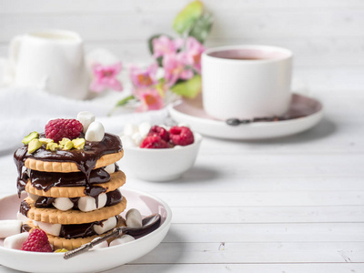 一个甜甜点的巧克力饼干覆盆子和棉花糖杯咖啡在一张台灯上