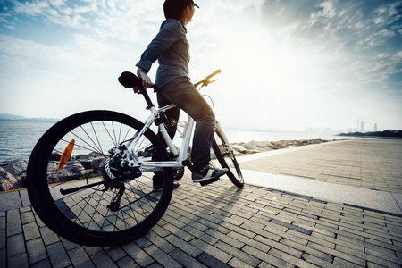 骑自行车的人看着美丽的风景，骑自行车在日出的海岸小路上