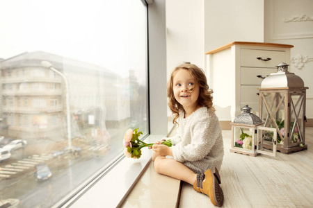 s day sits at the window and laughs at her mother, gives a bouqu