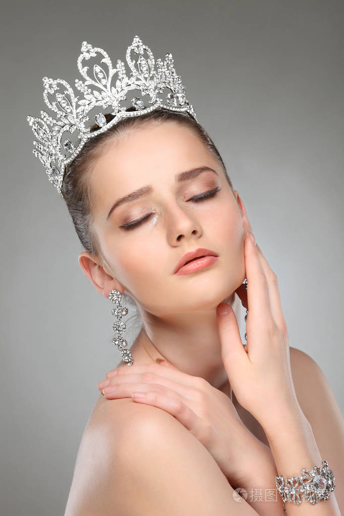 戴着皇冠的漂亮女孩,头上摆着灰色工作室背景
