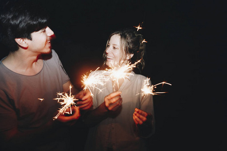 白种人男女夫妇玩火花庆祝和节日聚会的概念