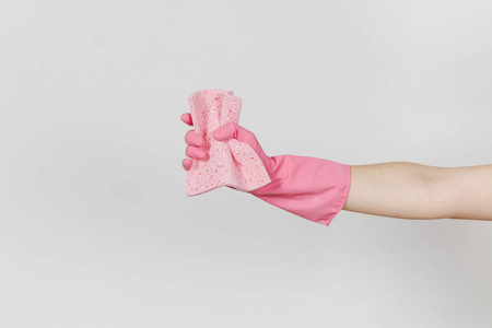 在粉红色的手套关闭女性手举行和挤压粉红色的吸水餐巾清洁和洗涤的菜肴, 在白色背景下隔离。清洁用品的概念。复制广告空间