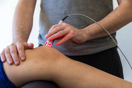 捏膝盖激光疗法用于治疗疼痛的膝盖上.选择性的焦点照片