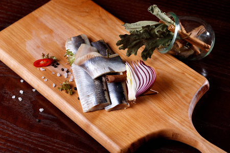 鲱鱼片在一张古老的乡村餐桌上的切割板上