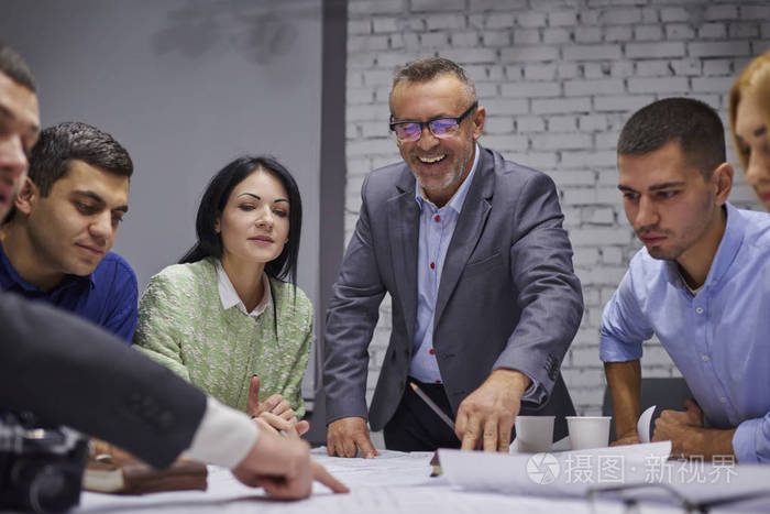 一群穿着正式服装的营销专家在办公室合作开展广告活动.