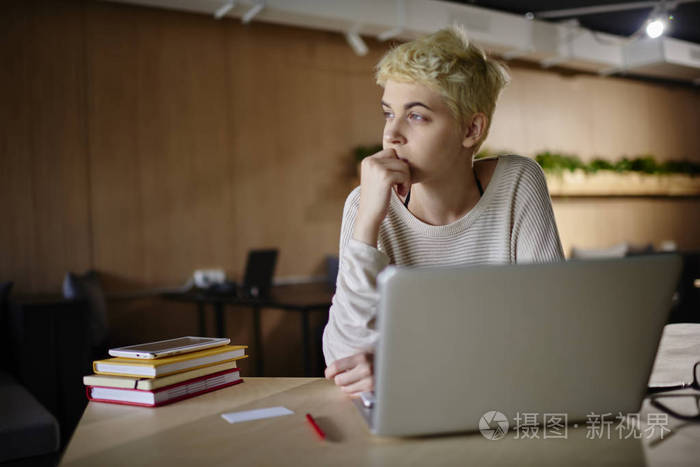 设计师思考项目的想法,坐在咖啡馆与阁楼室内专业自由职业者创造计划