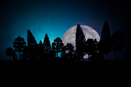 老神秘建筑在死树森林.树在晚上与月亮.超现实主义灯照片