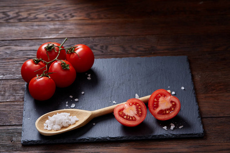 素食静物用新鲜的葡萄西红柿, 胡椒和盐在木勺木制的背景, 选择性重点
