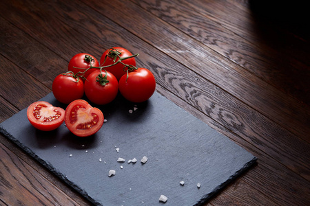 素食静物用新鲜的葡萄西红柿, 胡椒和盐在木勺木制的背景, 选择性重点