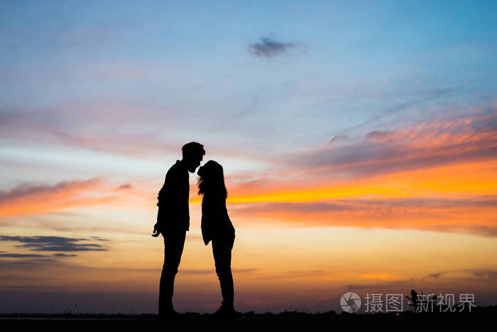 剪影年轻夫妇在爱情中享受美好的时光在日落