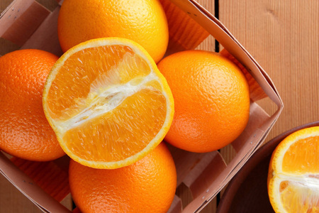一个木制盒子里的橘子，一个木制背景的柑橘，复古风格的柑橘，复制空间，橙色水果，一个棕色背景的热带水果，一个桌子上的盒子，半个橙色