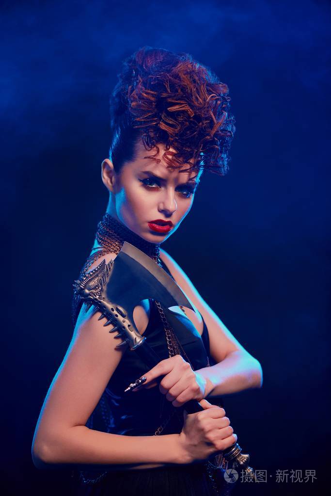 在深蓝色背景锋利的斧头的梦幻女郎的侧面视图