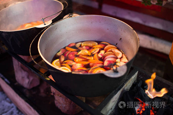 热 gluhwein 或在一个锅中的葡萄酒, 在公平, 当地的款待, 温暖和辛辣。一个热健康的传统柑橘饮料在公平。冬季节日的维他