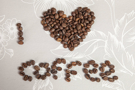 咖啡豆散落在桌上..黑咖啡的质地。心和铭文咖啡从咖啡豆。