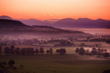 令人叹为观止的早晨景观的小巴伐利亚村被雾覆盖。 风景的巴伐利亚阿尔卑斯山日出与雄伟的山脉背景愤怒德国。