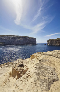 马耳他岛戈佐在德维拉泻湖和岩石海岸线附近的蔚蓝窗岩帆船的景色