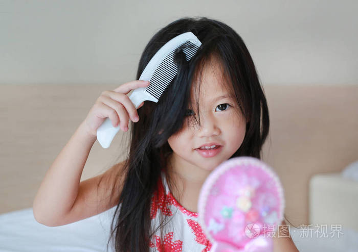 亚洲小女孩梳头看相机