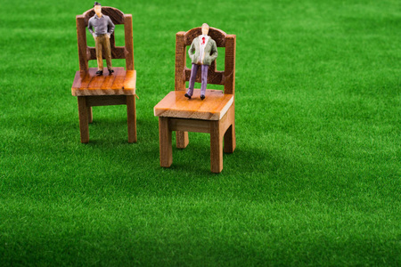 男人在人造草地上的木制玩具椅子上数字