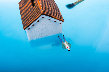 男女的小模型房子和雕像漂浮在水中