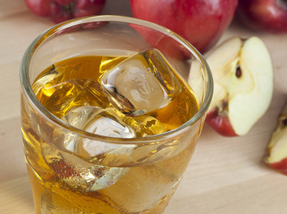 冰鲜水产品一杯新鲜冰冷的苹果汁, 苹果旁边有冰.照片