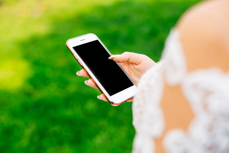 新娘手中拿着黑色屏幕的手机特写照片