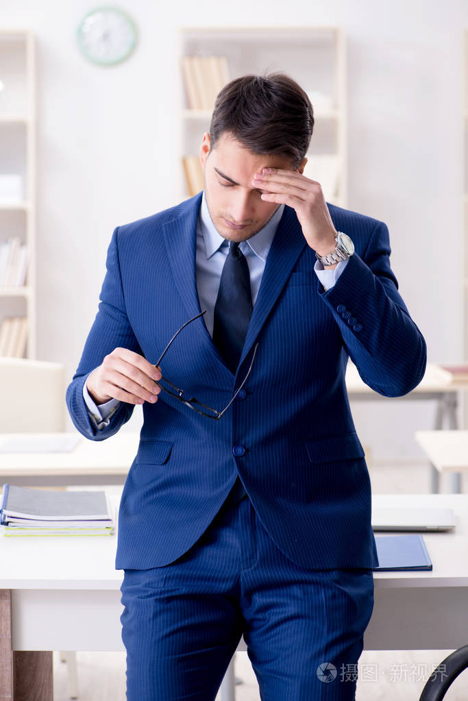 年轻英俊的生意人员工在办公室工作在办公桌上