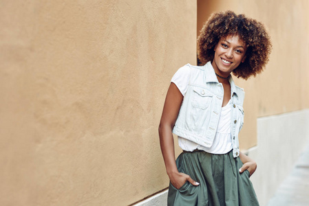 年轻的黑人妇女, 非洲的发型, 微笑的城市背景