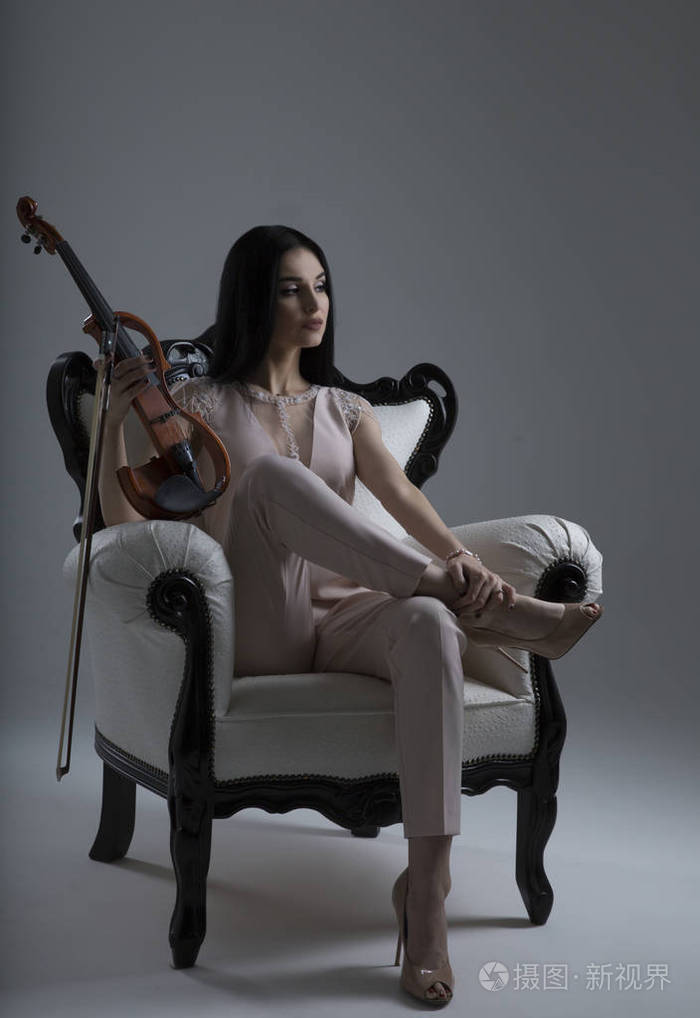 美丽的小提琴女坐在电动小提琴的 ch