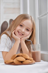 可爱的小女孩与饼干和巧克力牛奶
