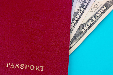 蓝色背景上有美元的红色护照。 旅行的概念