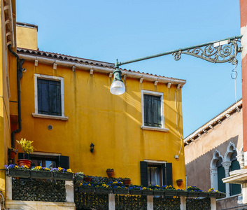 带花和长凳的黄色房子。意大利威尼斯附近布拉诺岛的五颜六色的房子。威尼斯明信片。欧洲旅游和旅游的著名场所