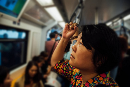 亚洲女子乘坐轻轨列车在城市照片