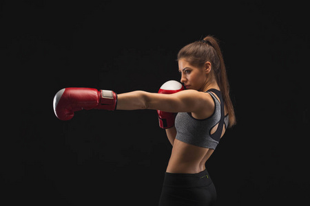 一个华丽的年轻女子与拳击手套侧面视图照片