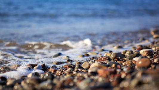 海浪拍打着砾石海滩，微距拍摄