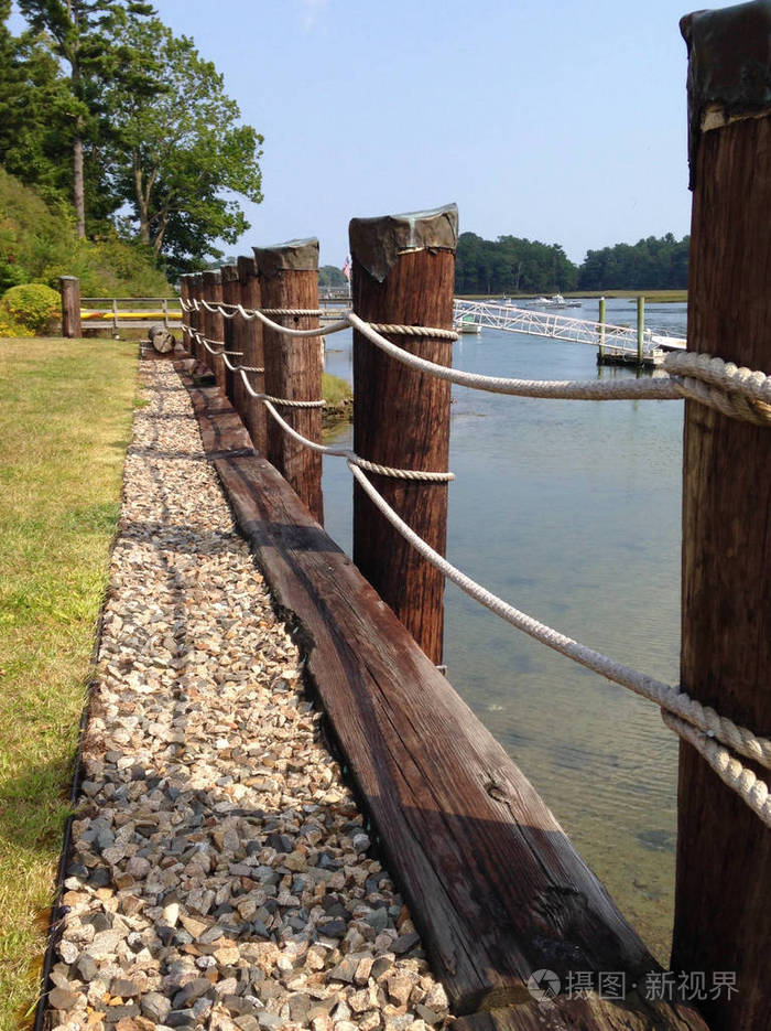 海湾海水旁的柱子和绳索围栏