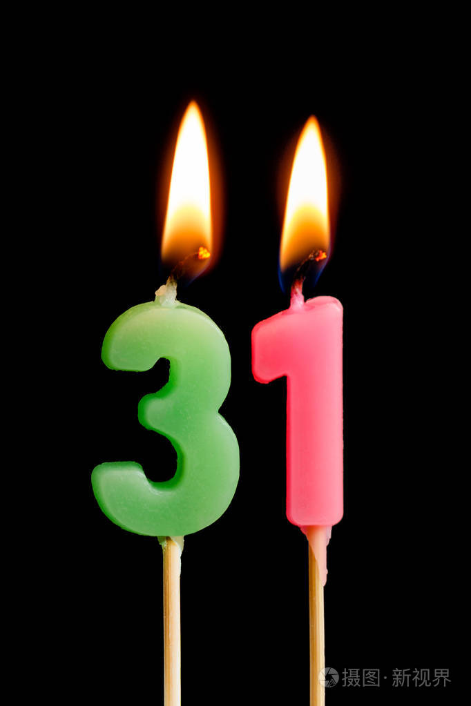 燃烧蜡烛的形式为31三十一数字日期的蛋糕孤立的黑色背景庆祝生日周年