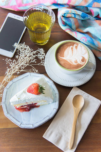 咖啡杯，美味的蛋糕，草莓，放松时间，莫布利在咖啡店的桌子上。