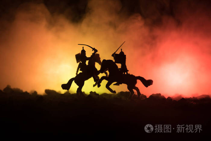 人物剪影作为分开的对象, 战斗在黑暗色调的雾背景的勇士之间.夜景